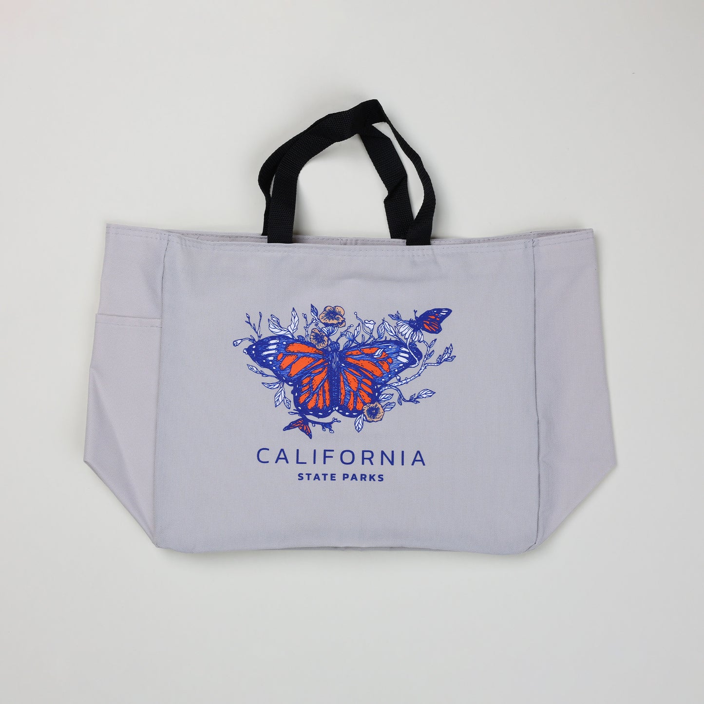 a stone colored tote bag featuring three monarch butterflies surrounded by flowers