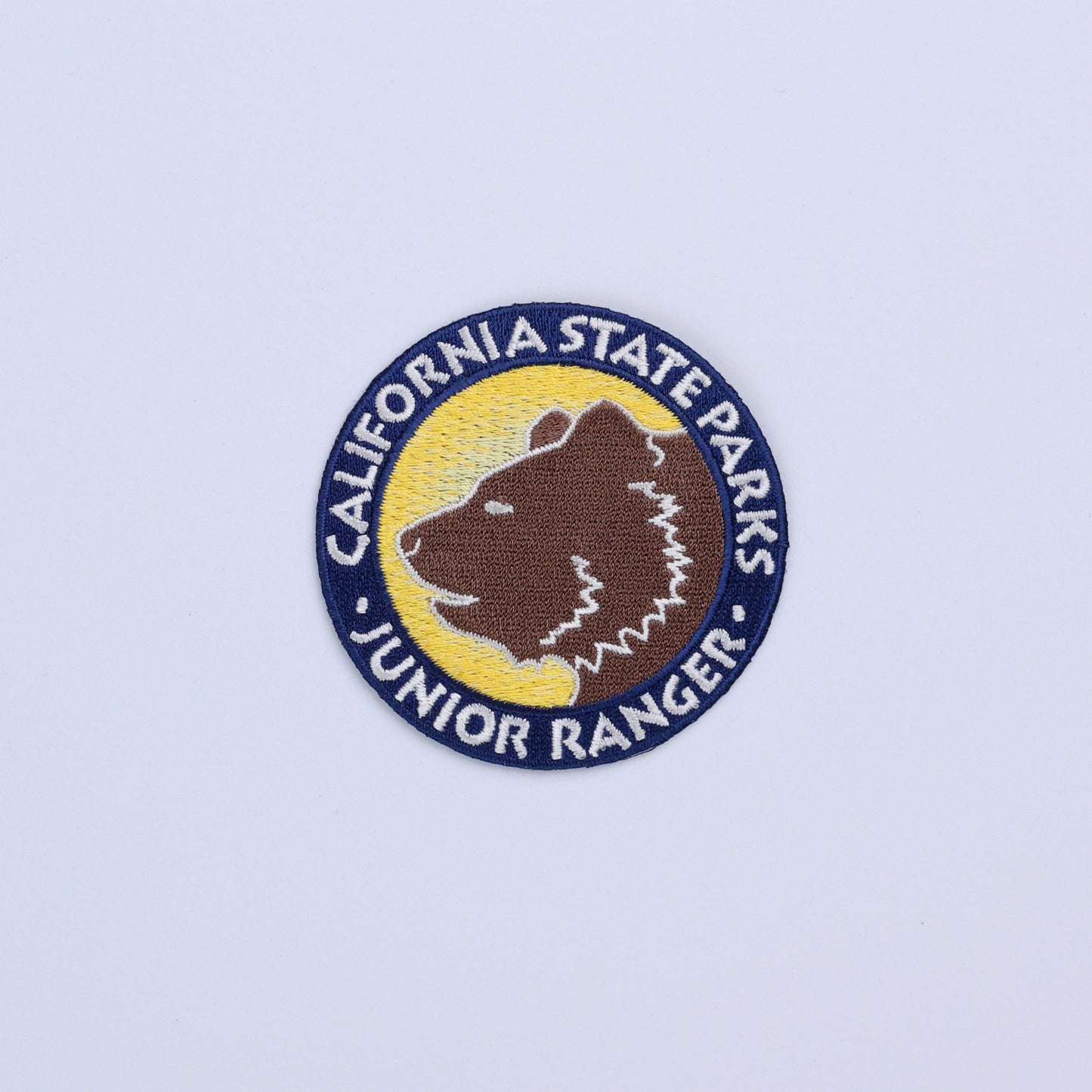 a round patch with the face of a grizzly bear surrounded by the words California State Parks Junior Ranger
