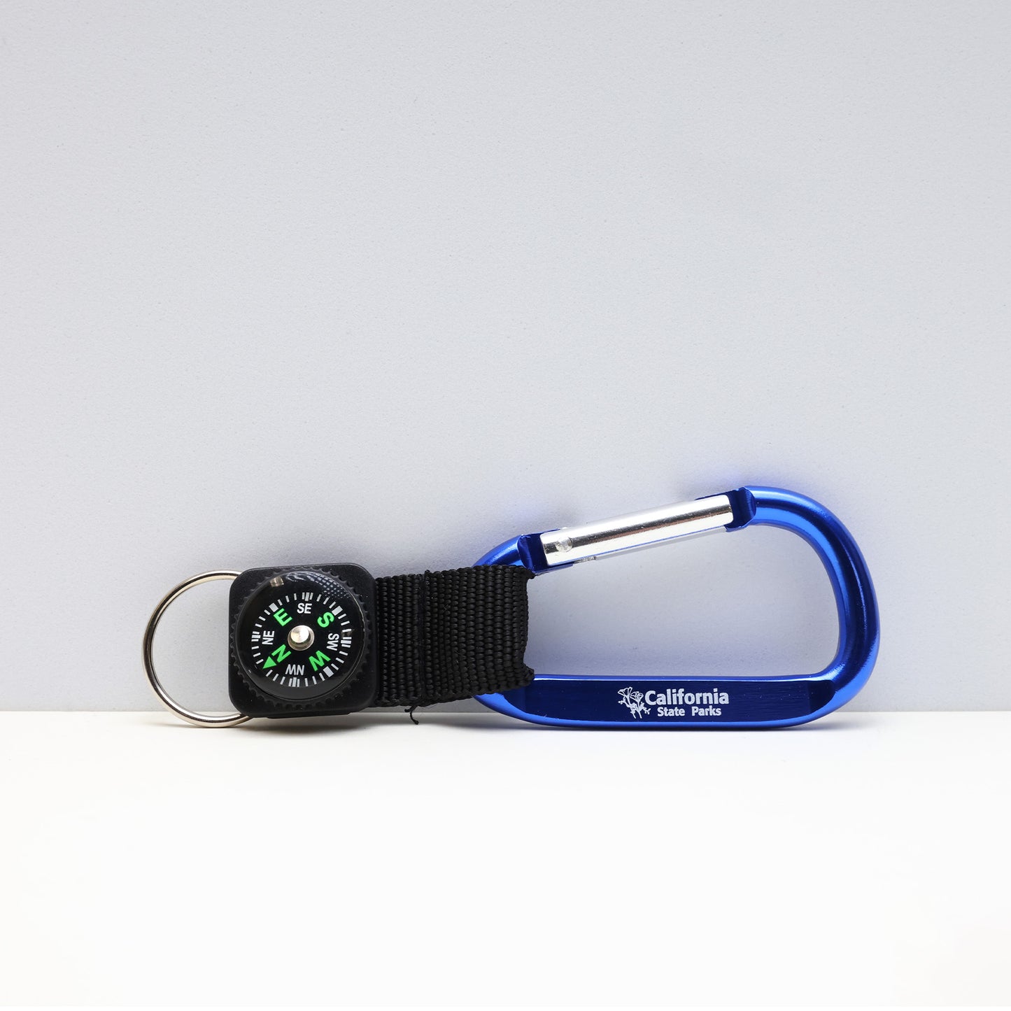 a small compass attached to a blue carabiner