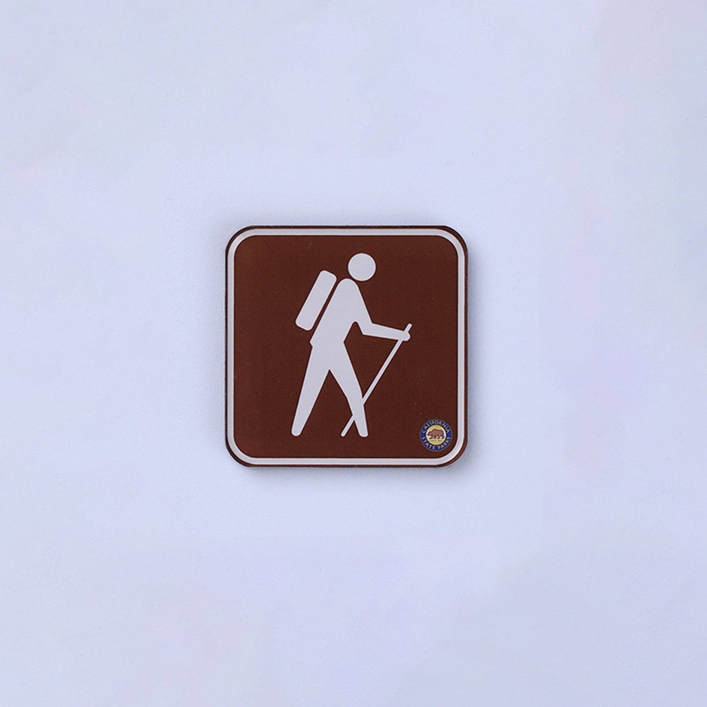 a square magnet that looks like a hiking sign