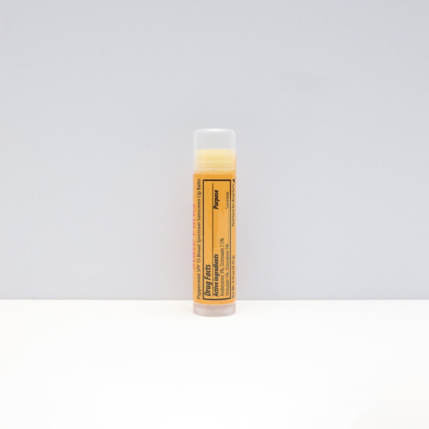 a yellow tube of lip balm featuring the ingredients label