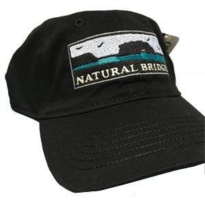 a black cap featuring an illustration of the Natural Bridges State Beach