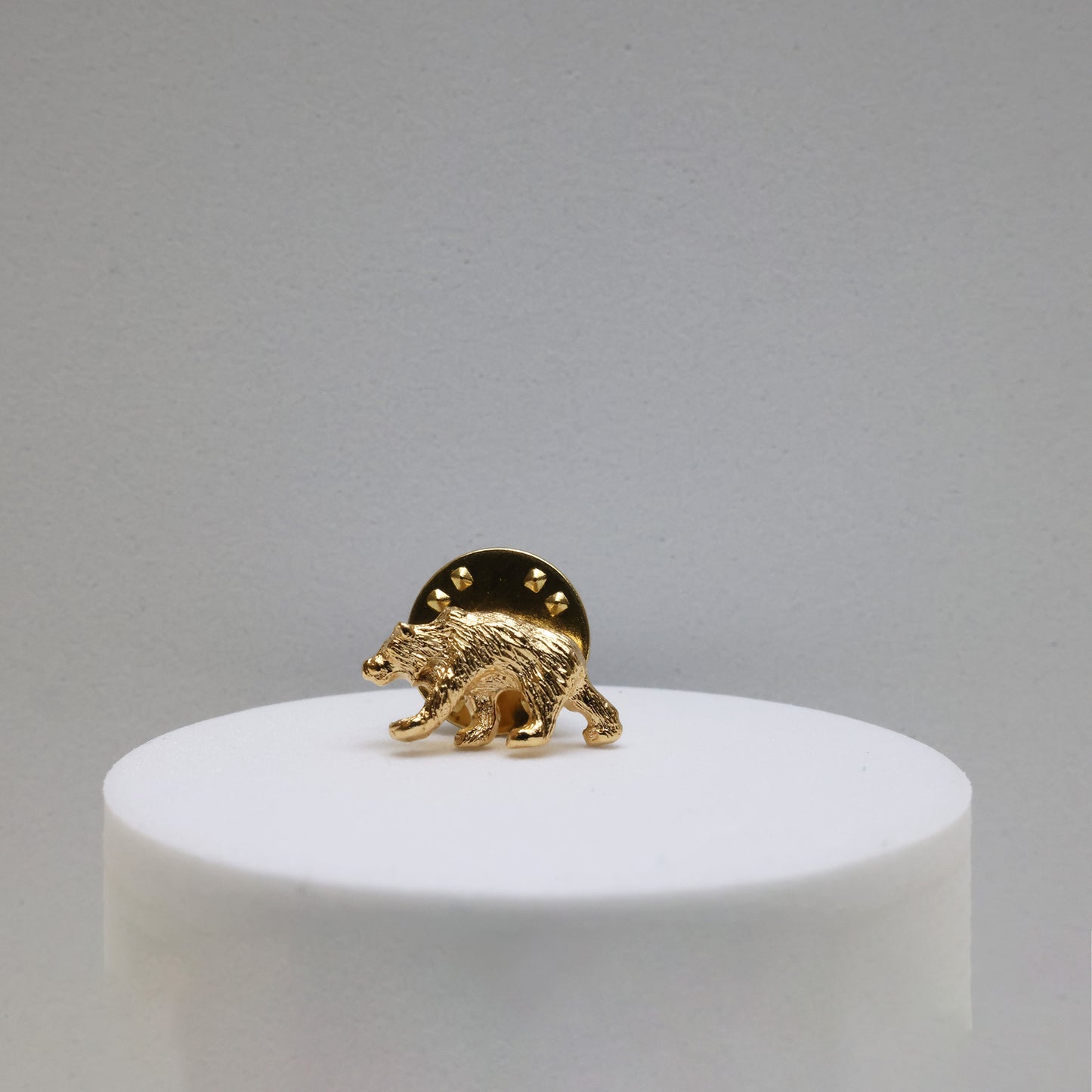 a gold plated grizzly bear shaped pin