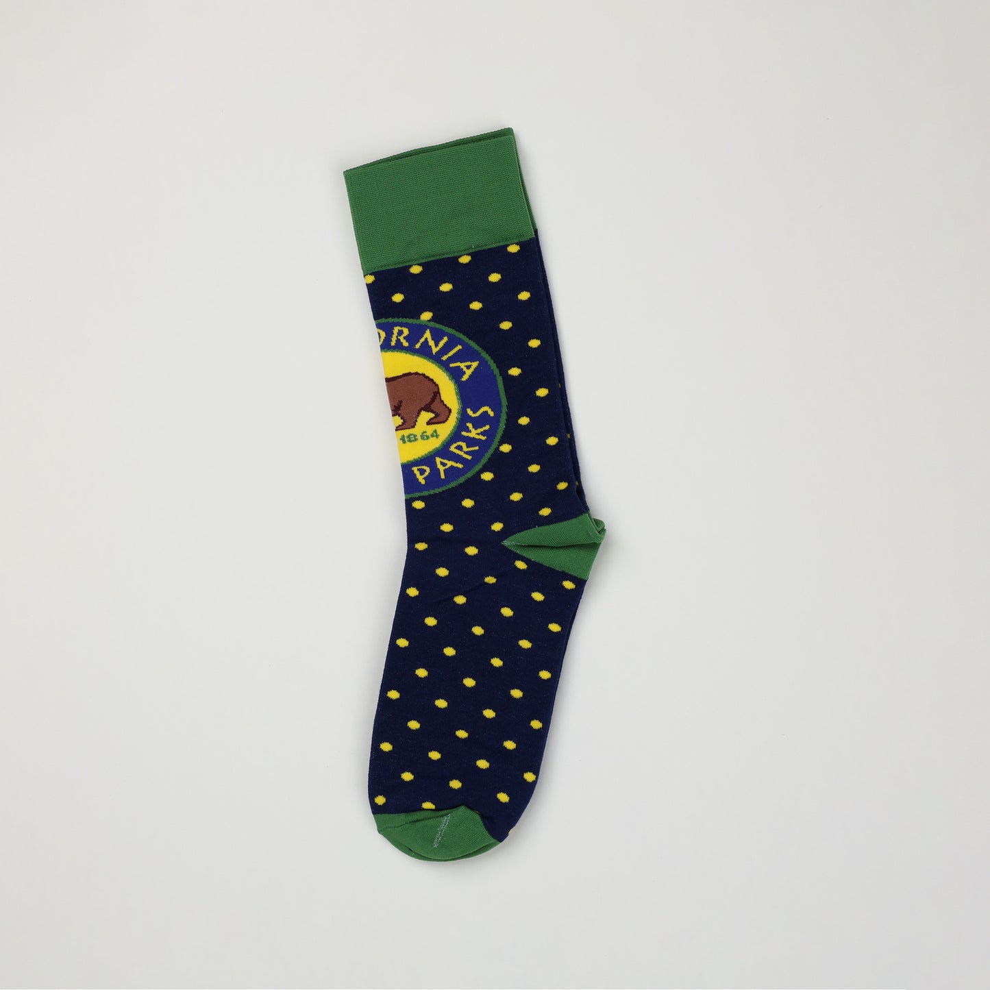 another side view of a navy blue sock with yellow spots, a green toe and heel, a green cuff, and a California State Parks logo