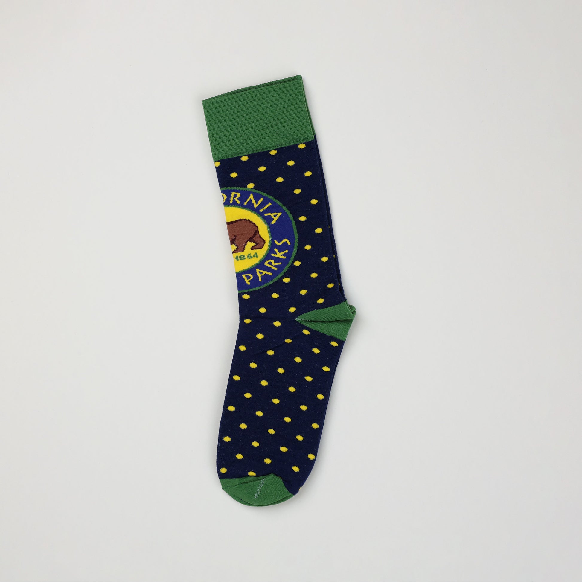 another side view of a navy blue sock with yellow spots, a green toe and heel, a green cuff, and a California State Parks logo