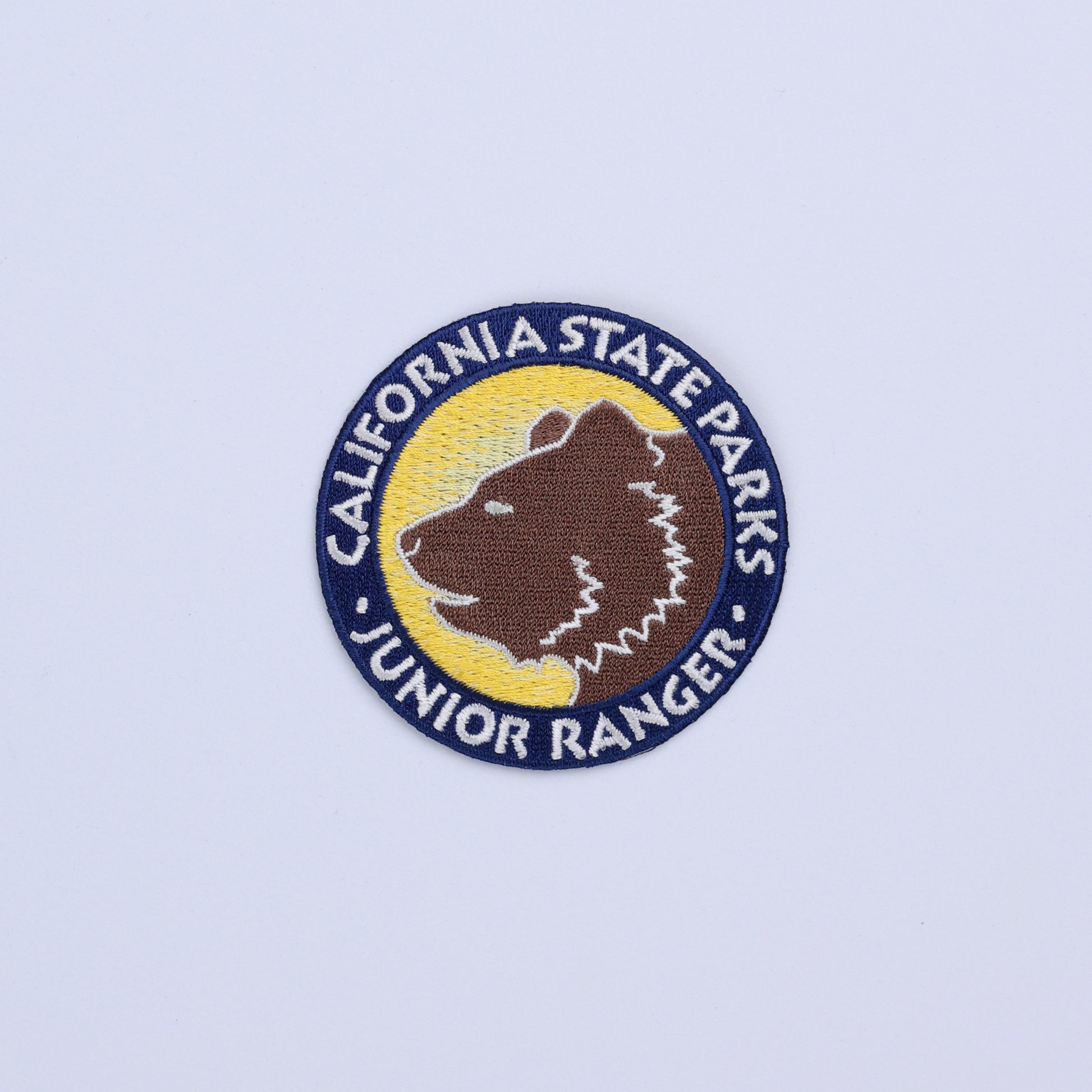 a round patch with the face of a grizzly bear surrounded by the words California State Parks Junior Ranger