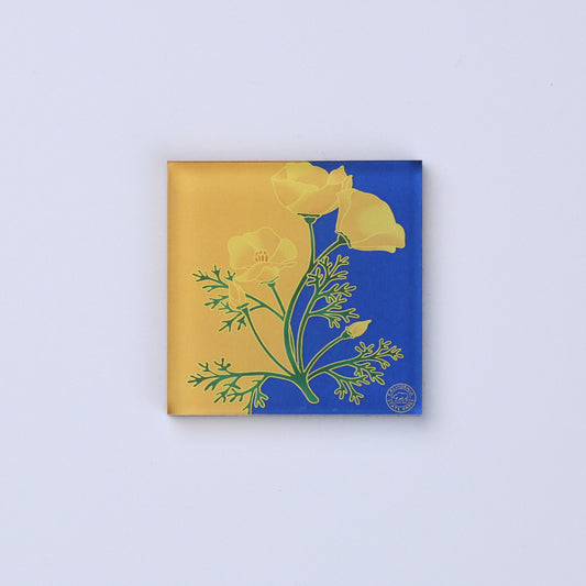 a square magnet in yellow and blue with a golden poppy in the center